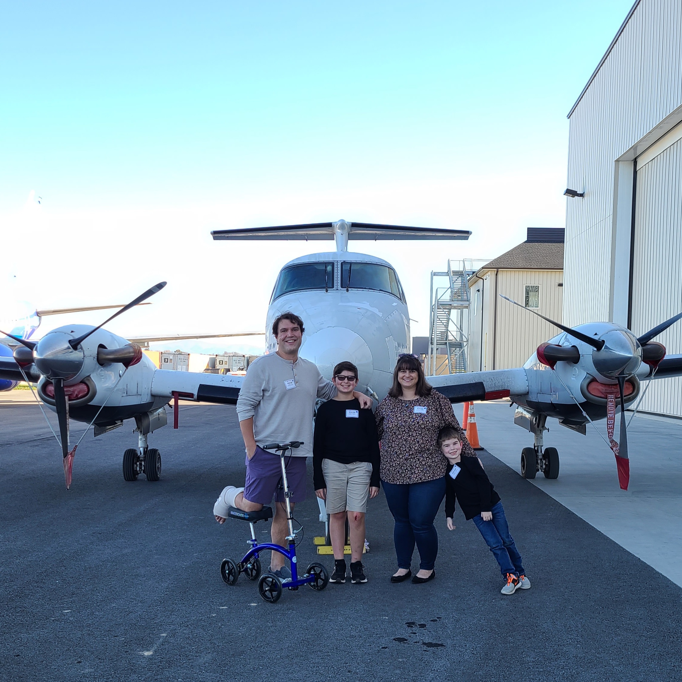 A family poses in front of a King Air